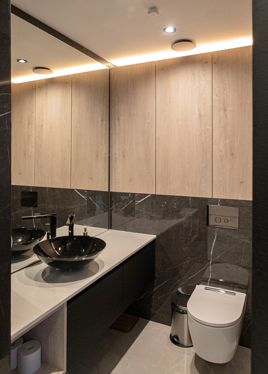 In the toilet, the lighting is created by spotlights and an LED strip on top of the cupboard
